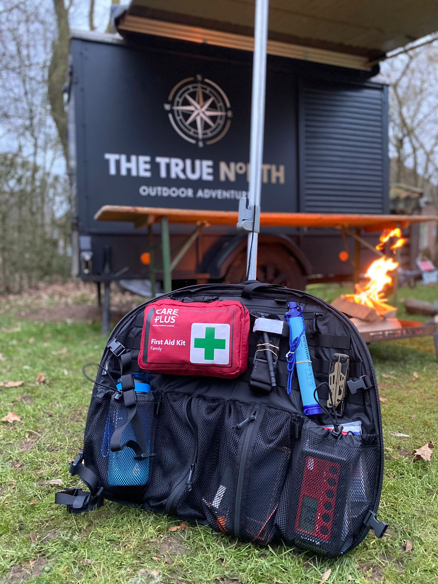 Open noodtas met noodspullen voor een aanhangwagen van The True North, met kampvuur op de achtergrond.